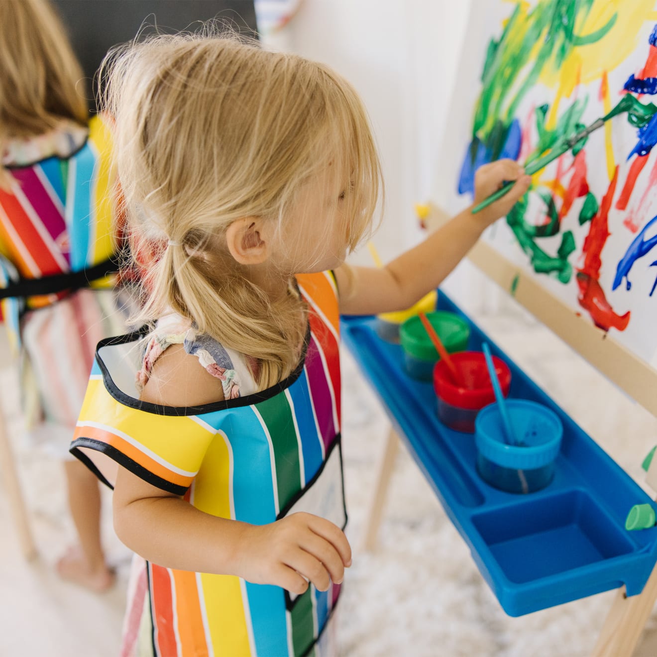 Child painting with the Melissa & Doug Easel Companion Accessory Set